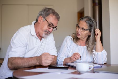 parents going over how to pay off their child's student debt before retirement; Tackle Student Loan Debt and Be Financially Free in Retirement