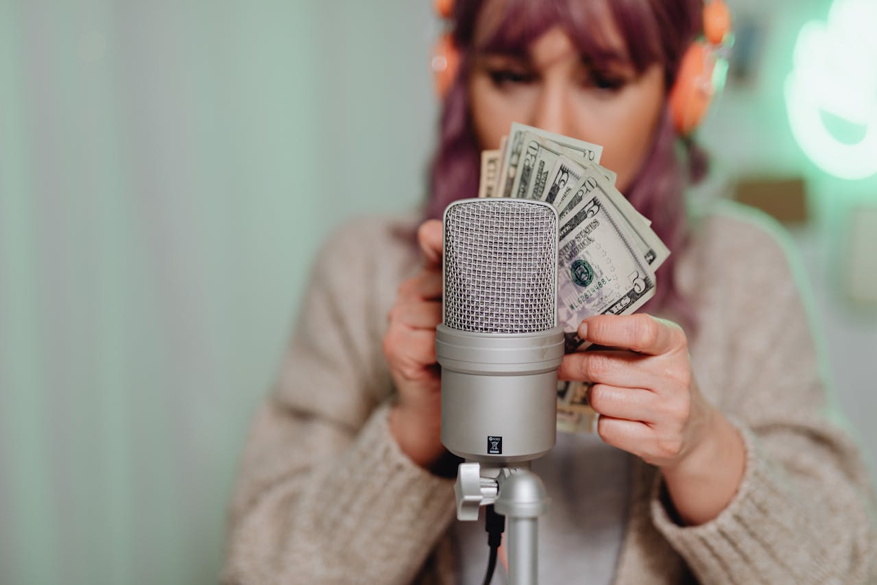 woman counting bills in front of a mic; I Built 9 Streams of Passive Income
