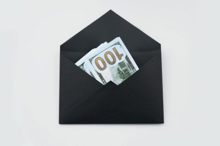 black envelop with money in it; Qualified Charitable Distributions (QCDs)
