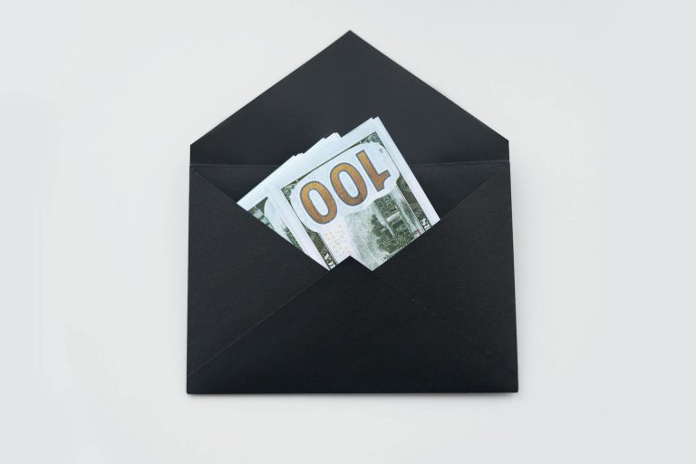 black envelop with money in it; Qualified Charitable Distributions (QCDs)
