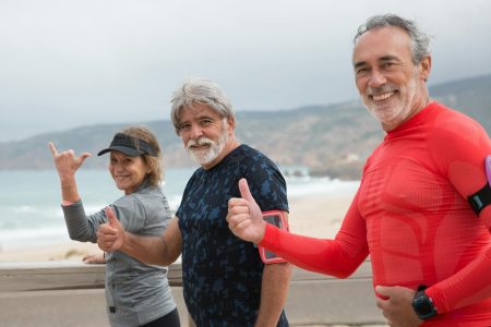 3 older men with thumbs pointing out at the beach; Why You Can't Afford to Ignore Guaranteed Income
