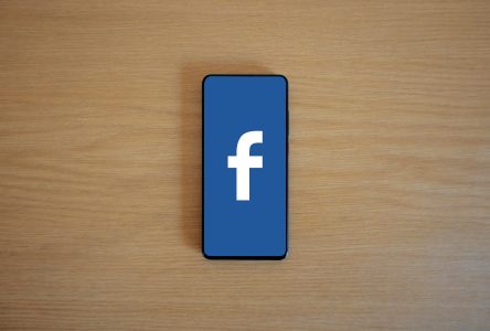 a phone with facebook on it on a wood background; Facebook Post Made Me $39,000 in One Month