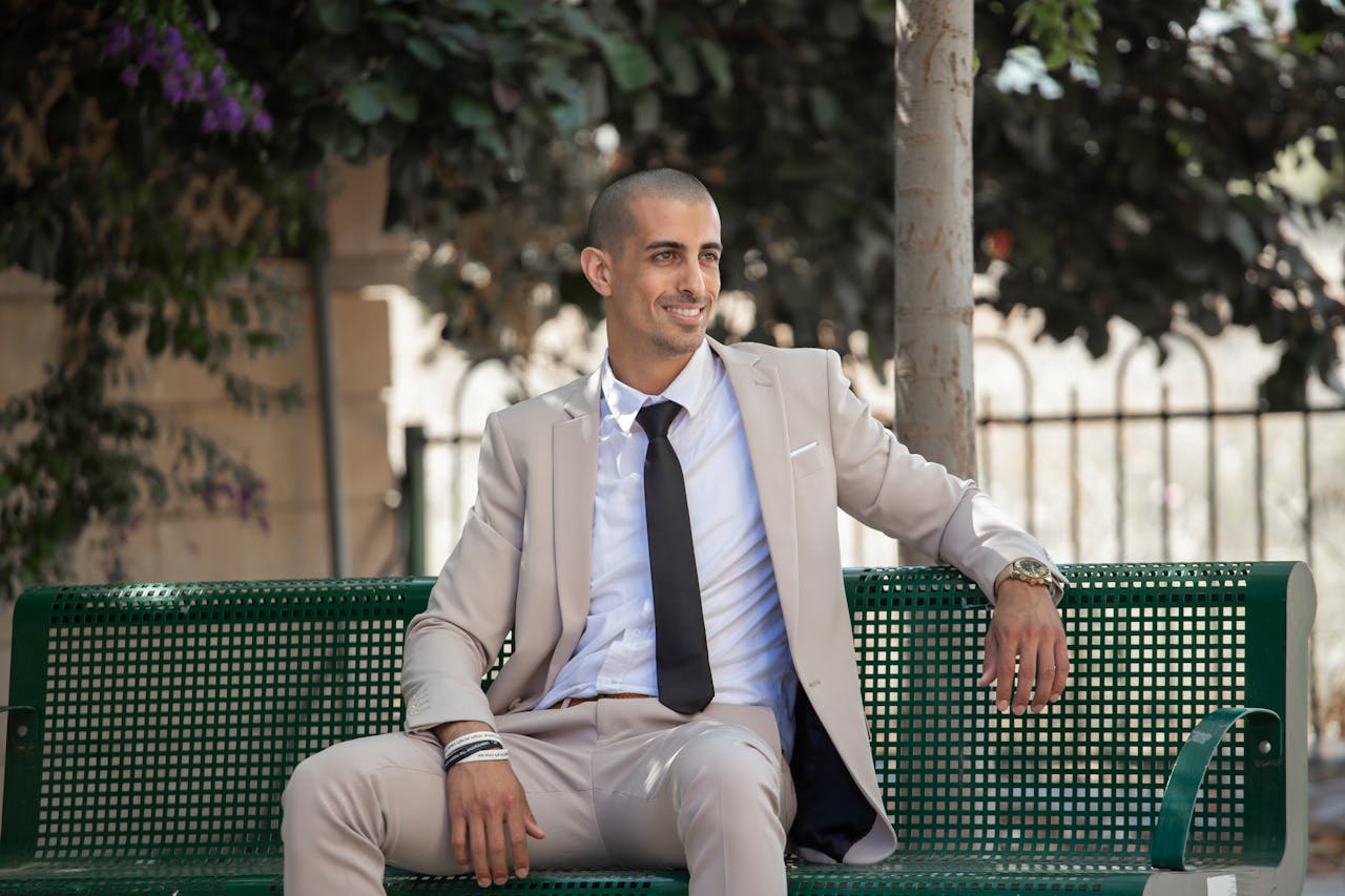 man in suit on park bench relaxing; Signs of Financial Success Most People Miss