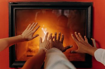 family holding hands toward the fireplace; 2026 Record-High Utility Bills
