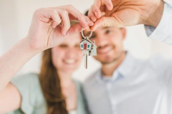 a couple with keys to their new home; Paid-Off Mortgage Retirement Investment