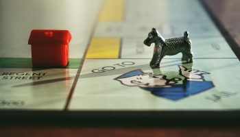 monopoly type game board with playing pieces; Old Money Rules vs. New Wealth Habits