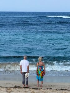 couple looking out at blue ocean; More Americans Are Moving Abroad to Retire