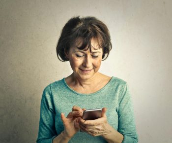 a retired women working on her phone; Navigating the Digital World An Essential Guide for Today’s Retirees