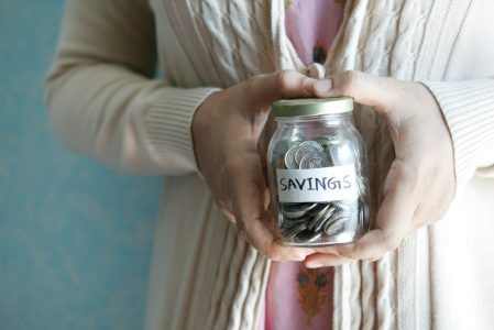 woman with money in a jar; Need $1.46 Million to Retire Comfortably and How to