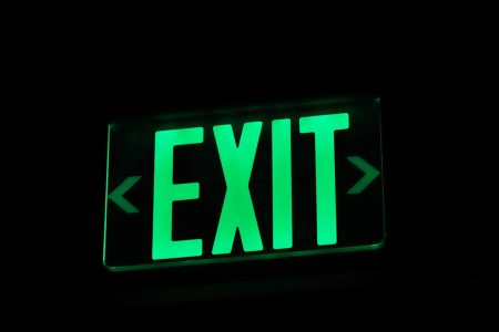 a green exit sign with black background; Zero Taxes on Business Exits