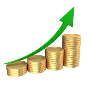 Stacks of coins with an upward trending green arrow