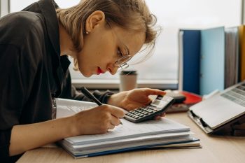 woman working on her business in economic downturn; Navigate Economic Exhaustion and Keep Your Startup Alive