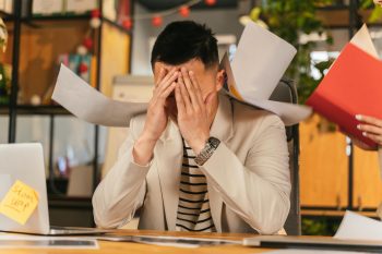 business man in cream colored suit covering his face; When Scaling Too Fast Backfires