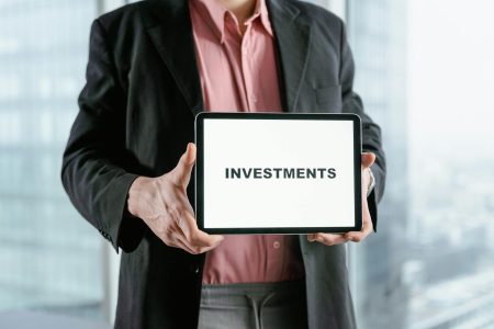 man in pink holding investments sign; Why Private Giants Are Rewriting Investing Rules