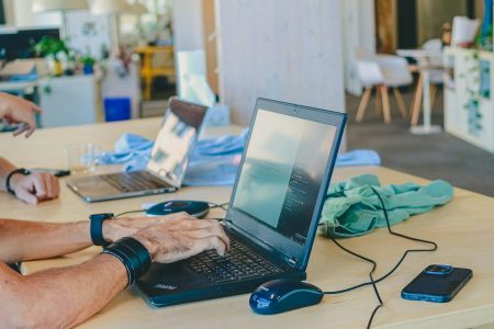 People working on laptops at a table; overlooked costs small businesses