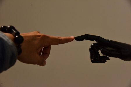 human and ai fingers touching; AI Handles the Math, But Humans Handle the Emotion