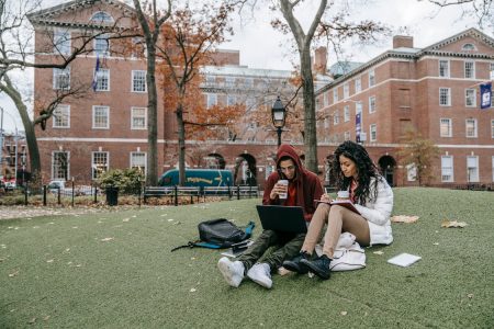 a couple sitting out on the lawn on a college campus; Financial Checklist Every Couple Should Complete Before Getting Married
