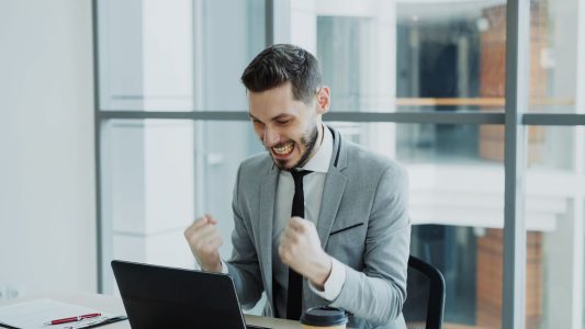 happy entrepreneur seeing more money in bank account; Financial Habits That Separate Wealthy Entrepreneurs