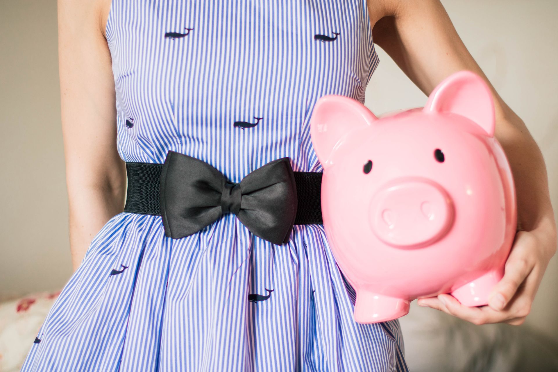 woman holding a pink piggy bank; How Much Should You Have in an Emergency Fund?
