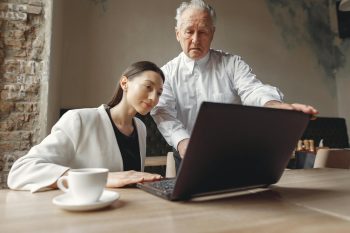 Multi-generational colleagues looking at a laptop screen; Silver Tsunami 65+ Demographic Is the Next Startup Frontier