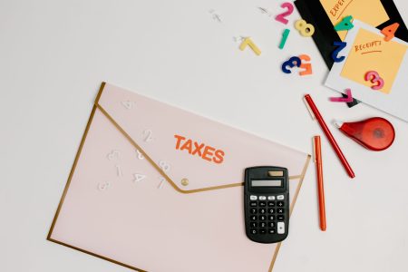 taxes typed on an envelope by a calculator; Social Security Can Spike Your Retirement Tax Bill