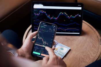 tracking money on a screen and phone; Two Investments That Made Me a Multi-Millionaire