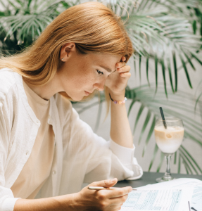 concerned woman working on past-due notices; How to Handle Late-Paying Clients