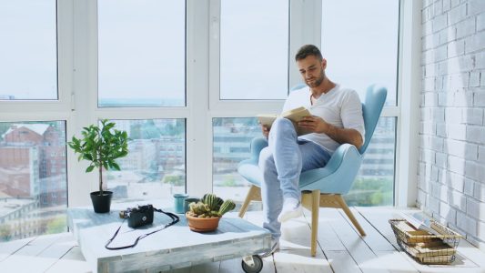 man enjoying his sunday morning reading; 101 Best Financial Freedom Quotes