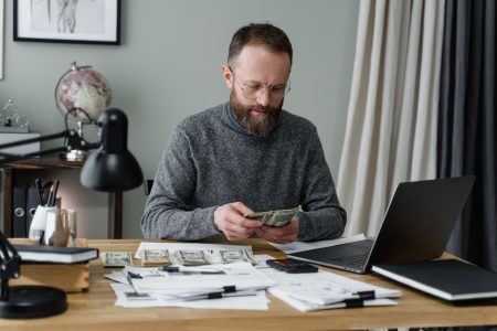 man counting the money he has earned and saved using his 401(k)