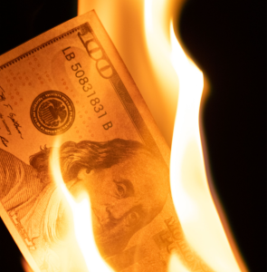 a dollar bill on fire; Why Investing More Can Mean Taking Less Risk