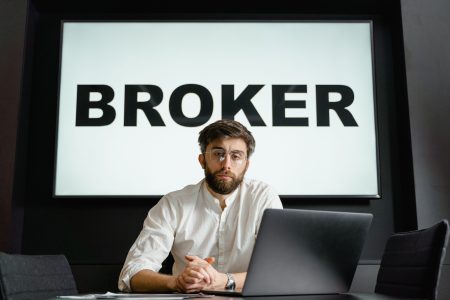 broker typed in big letters behind a person; Brokerage Account, How to Open One