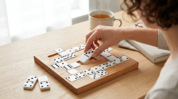 a woman doing the NYT dominos tile puzzle;
