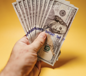 hand holding hundred dollar bills;