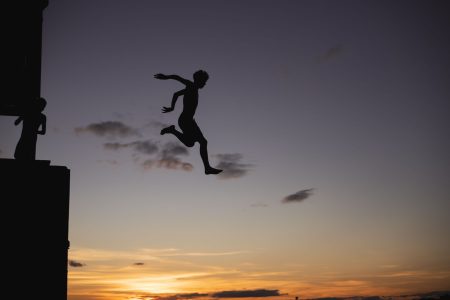 a person at risk jumping out into the twilight; Three Hidden Risks of High-Dividend Stocks