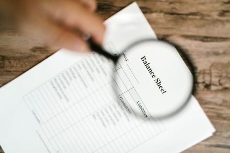 a balance sheet under a magnifying glass; What Is a Balance Sheet What Does It Tell You