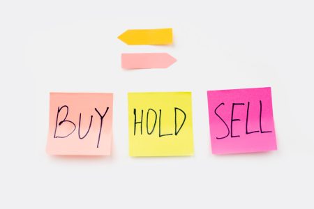 a white board with sticky notes buy, hold, sell what to do with stocks